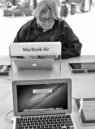 A woman using an Apple PC. California-based Apple directors, who put Chief Executive Officer Tim Cook at the top of the heap last year, are using compensation to retain the team that transformed the iPhone maker into the most valuable technology company. [China Daily]