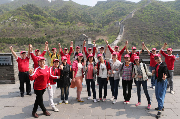 Young college students from central China's Hubei Province and some volunteers from Amway (China) Corporation pose for a photo after they arrive at the Great Wall in Beijing on Saturday, May 4, 2013. [Photo/CRIENGLISH.com] 