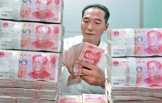 A worker counts and stacks banknotes at an Industrial and Commercial Bank of China branch in Huaibei, Anhui province. The yuan is allowed to trade within 1 percent in each direction around the daily reference rate set by the central bank. [China Daily]