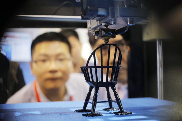  A visitor admires a model of a chair being printed on a 3-D printer at the China (Shanghai) International Technology Fair in Shanghai on Wednesday. [Photo / China Daily]