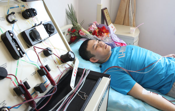Wang Yuanxiang in Changchun, Jilin province, donates blood stem cells for a 37-year-old leukemia patient on Monday. Wang, a 24-year-old student at the Jilin Institute of Physical Education, has been a regular blood donor for six years. [Photo/China Daily] 