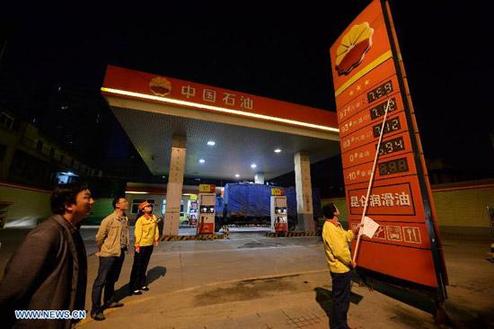 A gas station staff member changes the fuel price tags in Xi'an, capital of northwest China's Shaanxi Province, at the midnight on May 10, 2013. China slightly hiked gasoline and diesel prices starting May 10, the first increase since the fuel pricing scheme was reformed in March. 