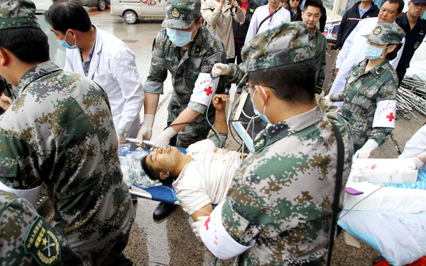An injured man is taken to a hospital after a landslide in Lushan county, Sichuan province, on Thursday. The man was hurt when rocks from the landslide buried three vehicles carrying nine people, leaving three dead, local authorities said.[Photo/China Daily]