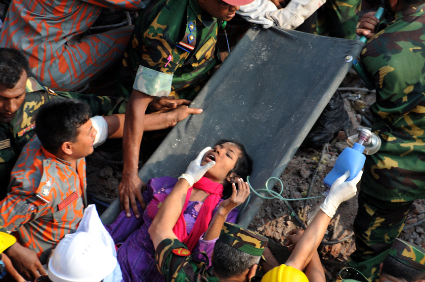 Rescuers help a female garment worker who survived the collapse of the eight-storey Rana Plaza building in Savar on the outskirts of Dhaka, Bangladesh, May 10, 2013. Rescuers on Friday evening found an garment worker named Reshmi who is still alive from piles of rubble of the building, 17 days after the collapse, the country&apos;s worst industrial disaster.