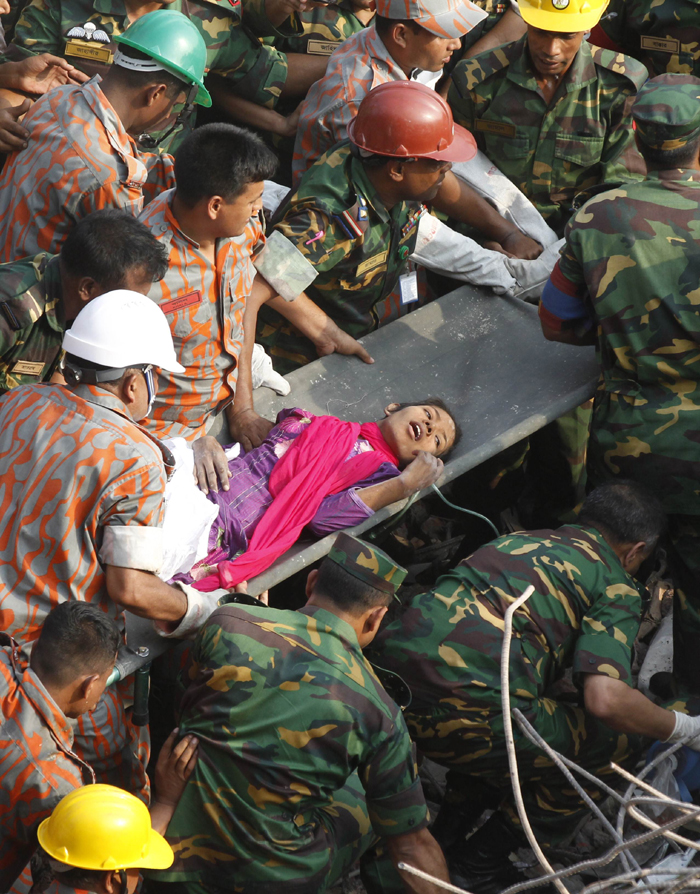 Rescuers help a female garment worker who survived the collapse of the eight-storey Rana Plaza building in Savar on the outskirts of Dhaka, Bangladesh, May 10, 2013. Rescuers on Friday evening found a garment worker named Reshmi who is still alive from piles of rubble of the building, 17 days after the collapse, the country&apos;s worst industrial disaster. 