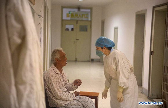 An 80-year-old H7N9 avian influenza patient, who has made full recovery, talks with a medical worker in hospital in Nanchang, Jiangxi Province, May 8, 2013. 