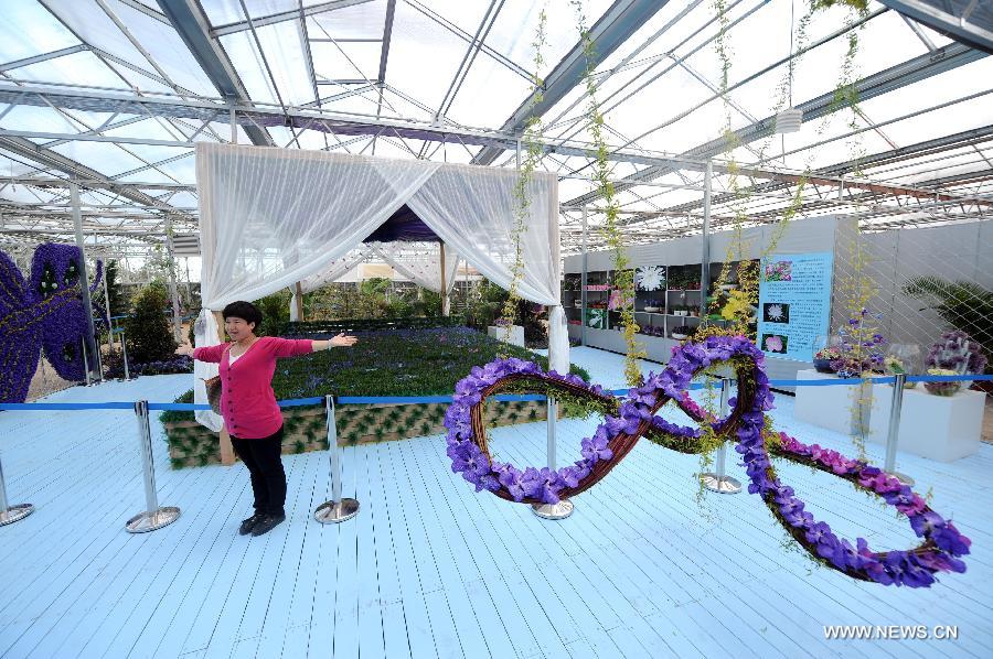 A tourist poses for a photo at the flower park in the 2013 World Landscape Art Exposition Jinzhou China, in Jinzhou, northeast China's Liaoning Province, May 10, 2013. The exposition kicked off on Friday, attracting more than 300 artists from at home and abroad. (Xinhua/Yang Qing) 