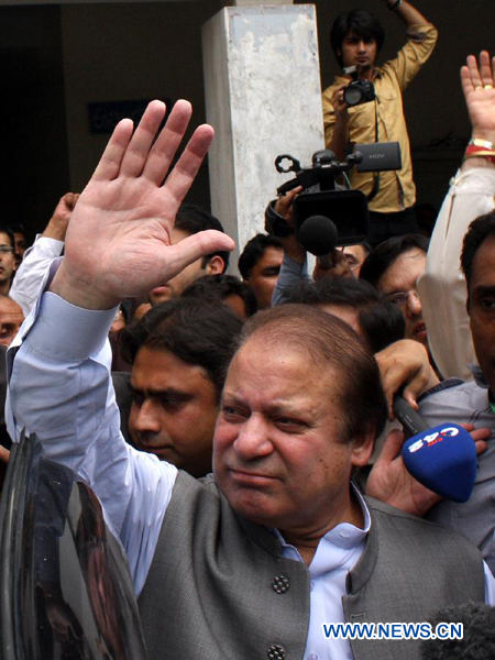 FormerPakistani Prime Minister Nawaz Sharif (Front) waves to supporters as he arrives to cast his vote in eastern Pakistan's Lahore, May 11, 2013. (Xinhua/Jamil Ahmed)