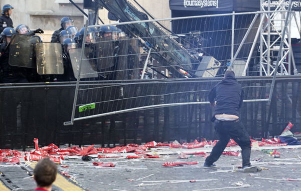  A youth throws a fence toward riot police during Paris Saint-Germain soccer club celebrations for winning the the French league title at Trocadero Plaza in Paris.