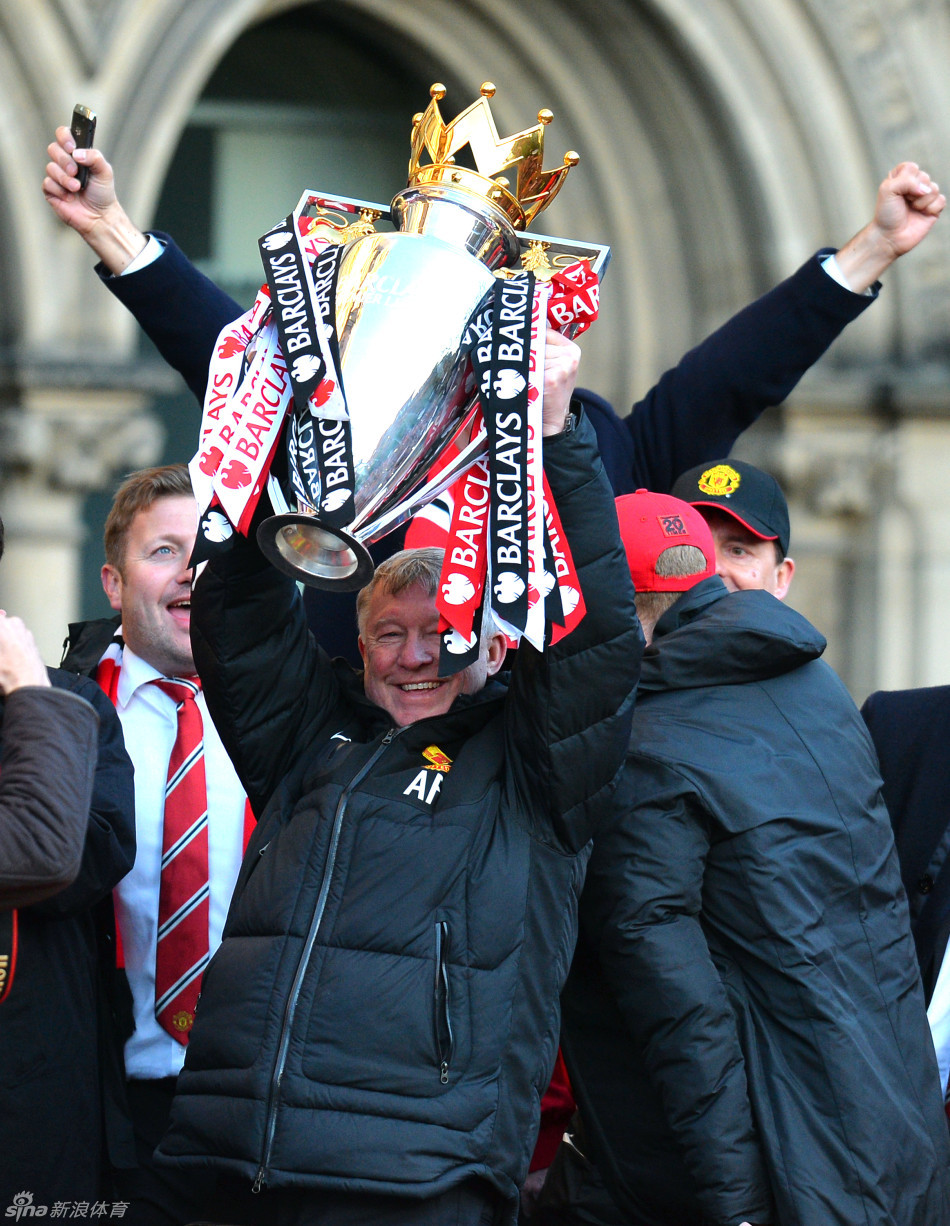 Sir Alex Ferguson lifts the Premier League trophy on the bus. 