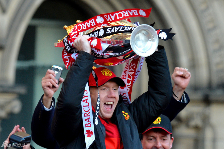 Paul Scholes lifts the Premier League trophy on the bus. 
