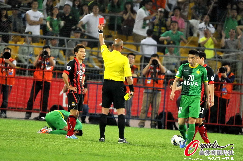 Choi Hyo-jin of FC Seoul receives a red card after fouling on Wang Xiaolong, left, of Beijing Guoan during their first leg game of AFC Champions league last 16 at the Workers' Stadium in Beijing, May 14, 2013. 