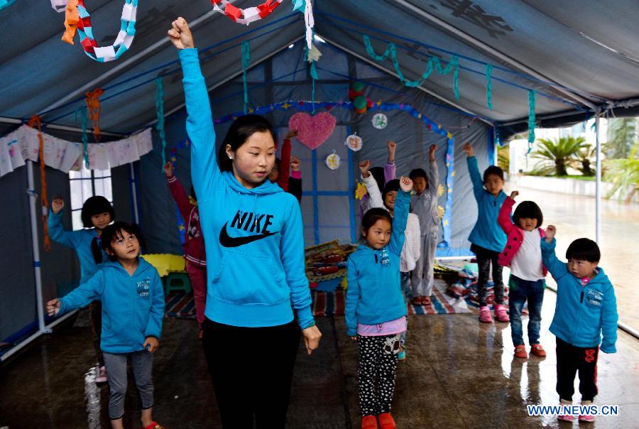 Children take a dance class in a temporarily-erected tent in Lushan County, southwest China's Sichuan Province, May 17, 2013. 