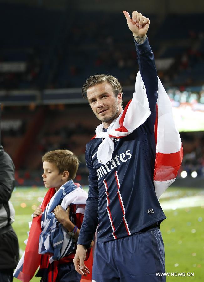 Paris Saint-Germain's English midfielder David Beckham gestures to the crowd with his son Romeo during the celebration for winning the French League 1 title after the League 1 football match between Paris St Germain and Brest at Parc des Princes stadium in Paris on May 18, 2013. [Wang Lili/Xinhua]