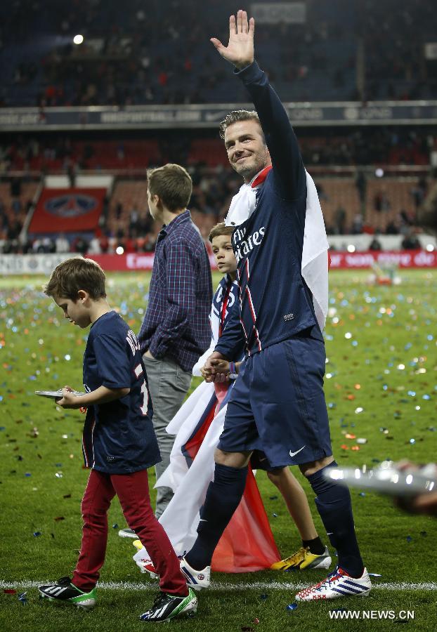 Paris Saint-Germain's English midfielder David Beckham waves to the crowd with his sons, Brooklyn, Romeo and Cruz during the celebration for winning the French League 1 title after the League 1 football match between Paris St Germain and Brest at Parc des Princes stadium in Paris on May 18, 2013. [Wang Lili/Xinhua]