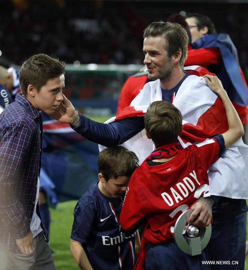 Paris Saint-Germain's English midfielder David Beckham talks with his sons, Brooklyn (L), Romeo (R) and Cruz (C) during the celebration for winning the French League 1 title after the League 1 football match between Paris St Germain and Brest at Parc des Princes stadium in Paris on May 18, 2013. [Wang Lili/Xinhua]