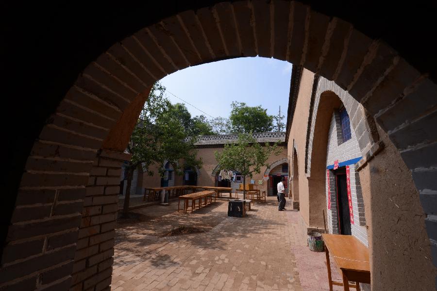 Photo taken on May 18, 2013 shows a renovated sunken courtyard in Qucun Village of Zhangbian Township in Shaanxian County, central China's Henan Province. The sunken courtyard, a kind of traditional residential construction in west Henan, has a high value in the study of local histroy, architecture, geology and sociology. The Qucun Village has 115 sunken courtyards, most of which are under protective reconstruction. [Zhao Peng/Xinhua]