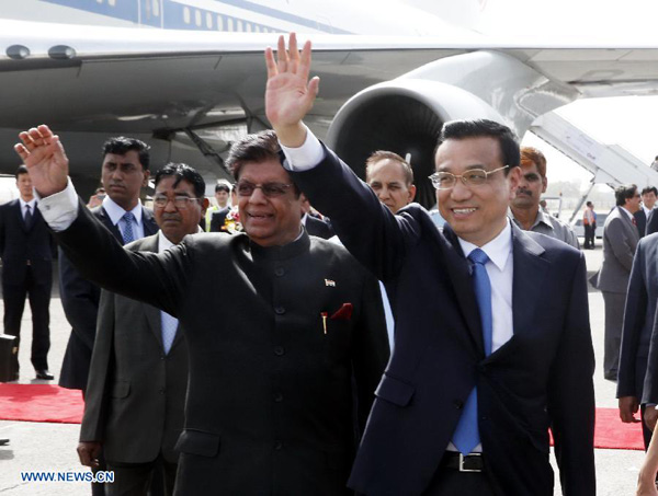 Chinese Premier Li Keqiang (R, front) waves upon his arrival at an airport in New Delhi, India, kicking off an official visit to the country, on May 19, 2013. [Ju Peng/Xinhua]
