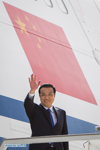 Chinese Premier Li Keqiang waves upon his arrival at an airport in New Delhi, India, kicking off an official visit to the country, on May 19, 2013. [Zheng Huansong/Xinhua]