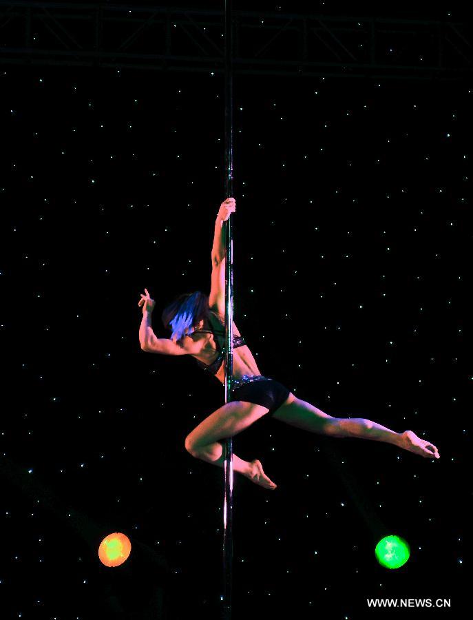 A dancer of China's National Pole Dancing Team performs in 'Fairies on the Pole,' the world's first pole dance drama, in Tianjin, north China, May 17, 2013. [Zhai Jianlan/Xinhua]