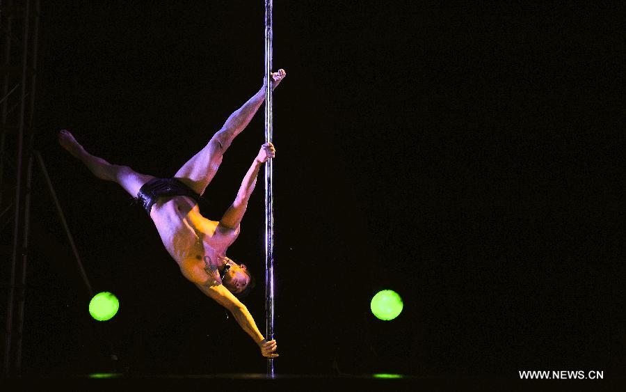 A dancer of China's National Pole Dancing Team performs in 'Fairies on the Pole,' the world's first pole dance drama, in Tianjin, north China, May 17, 2013. [Zhai Jianlan/Xinhua]