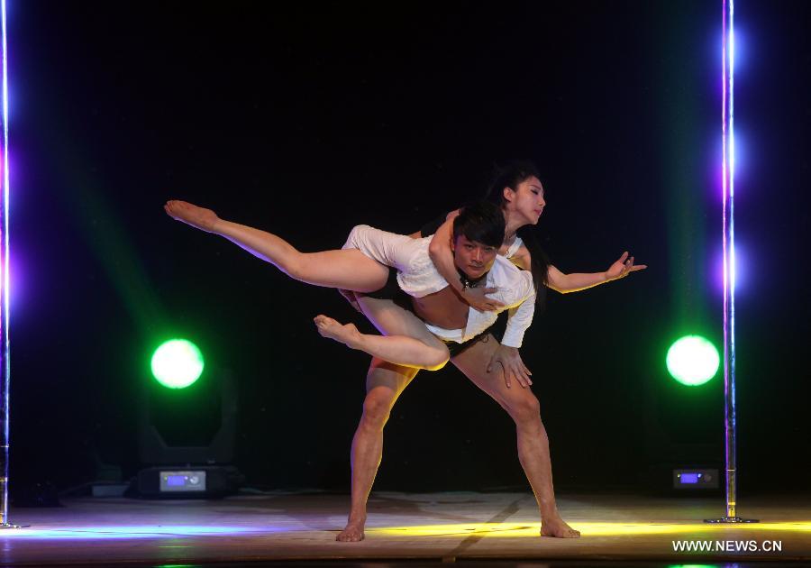 Dancers of China's National Pole Dancing Team perform in 'Fairies on the Pole,' the world's first pole dance drama, in Tianjin, north China, May 17, 2013. [Liu Dongyue/Xinhua]