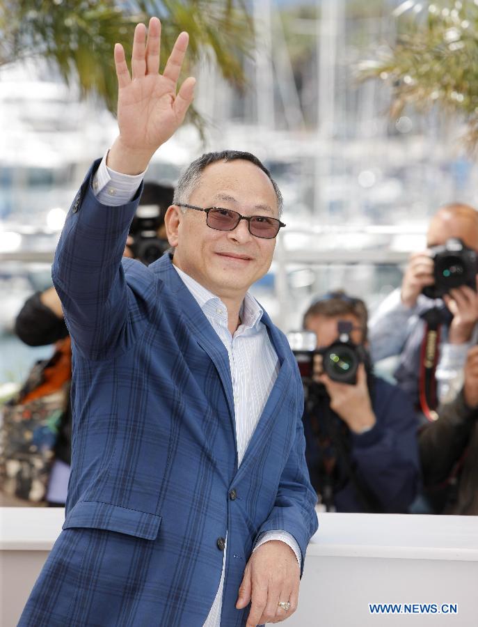 Chinese Hong Kong film director Johnnie To waves during the photocall for Hong Kong film 'Blind Detective' at the 66th Cannes Film Festival in Cannes, southern France, on May 20, 2013. The film 'Blind Detective' is presented in Midnight Projections at the film festival. [Zhou Lei/Xinhua]