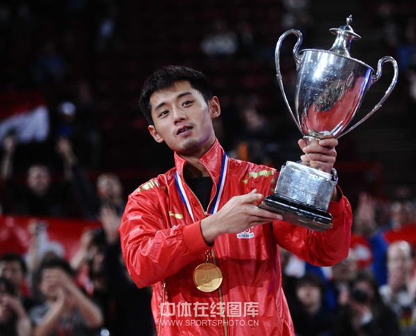  Zhang lifts the trophy after retaining men's singles title.