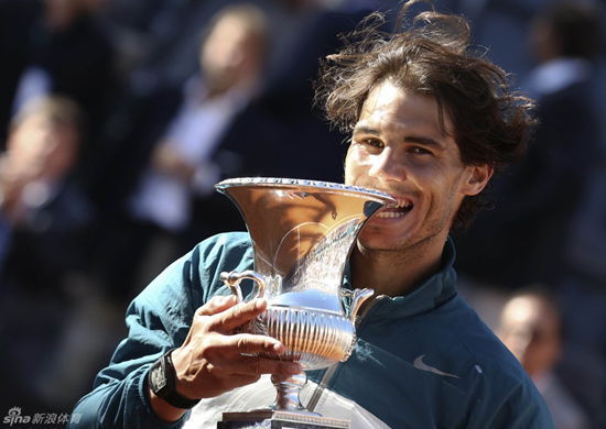 Nadal bites the trophy after winning Rome Masters.