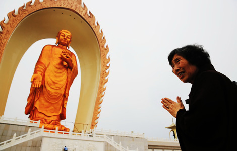 A woman prays in front of the Buddha statue in Jiujiang, East China's Jiangxi province, May 19, 2013. [Photo/Asianewsphoto]