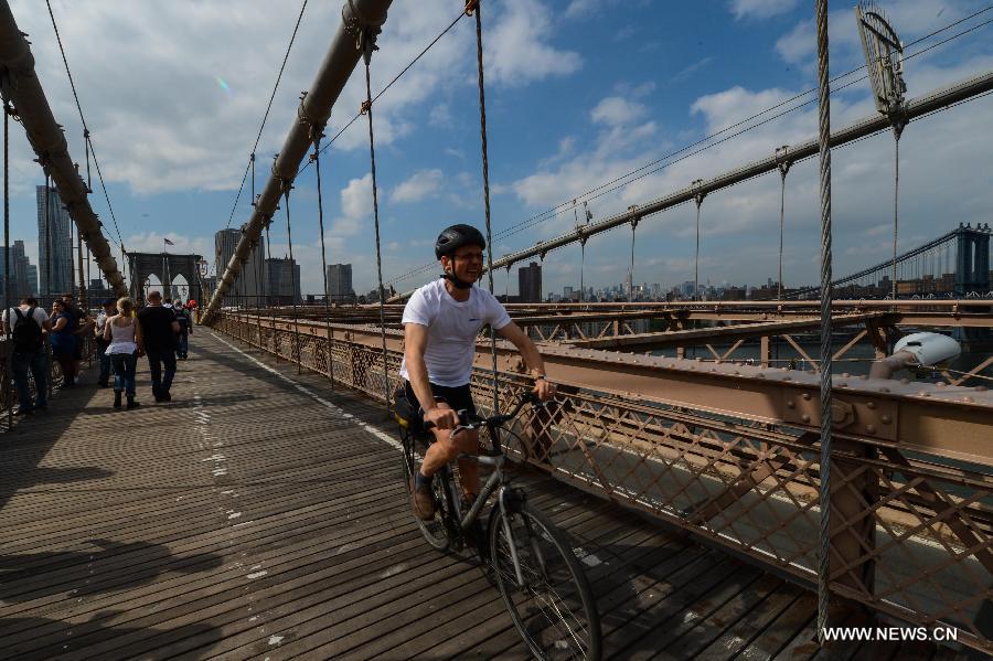 A man rides bicycle on the Brooklyn Bridge in New York, the United States, on May 20, 2013. The Brooklyn Bridge, opened on May 24, 1883, will celebrate its 130th birthday this week. (Xinhua/Niu Xiaolei) 