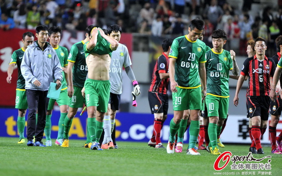 Beijing Guoan players walk off the pitch dejected. 