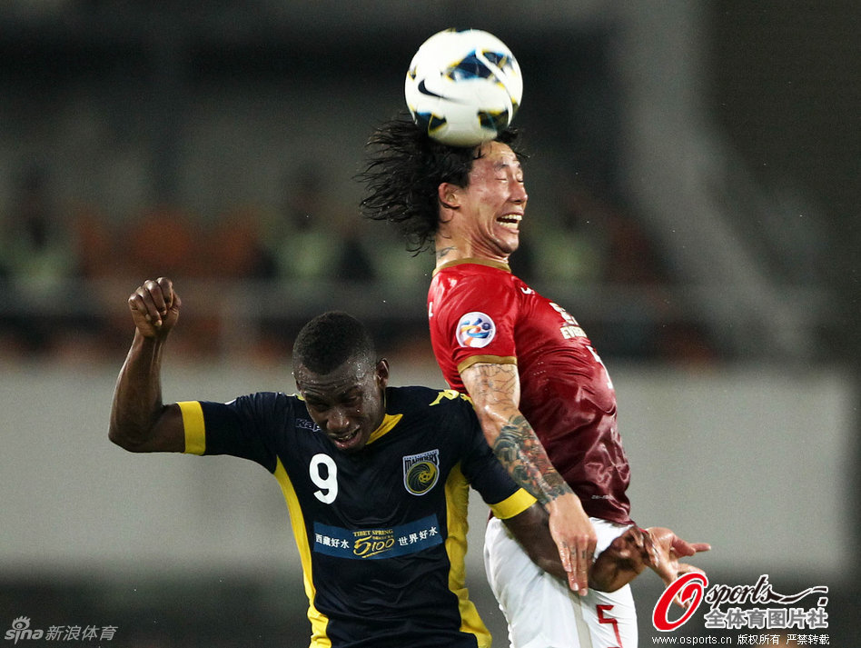  Zhang Lingpeng jumps for the header.