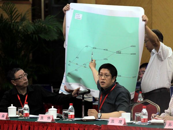 Zhang Wei, an official at the Beijing transport commission, displays statistics at a hearing on Thursday on a possible taxi-fare increase. [Photo/China Daily]