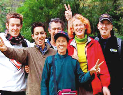 68-year-old 'Mama Moon' (middle) with foreign tourists. [Photo/sina.com.cn]