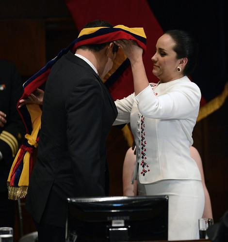 National Assembly President Gabriela Rivadeneira (R) places the presidential sash on President Rafael Correa during the inauguration of his third term (2013-2017) in Quito, on May 25, 2013. [Xinhua photo] 