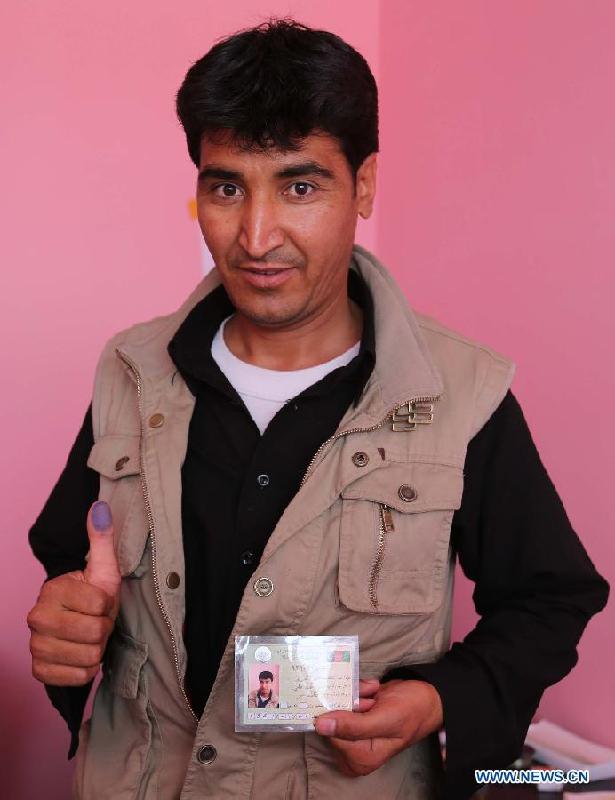 An Afghan man shows his voter registration card at a voter registration center in Ghazni province, eastern Afghanistan, on May 26, 2013. The voter registration process for the general elections scheduled for April 5, 2014 started in Afghanistan on Sunday, the country&apos;s election commission said in a press release. 