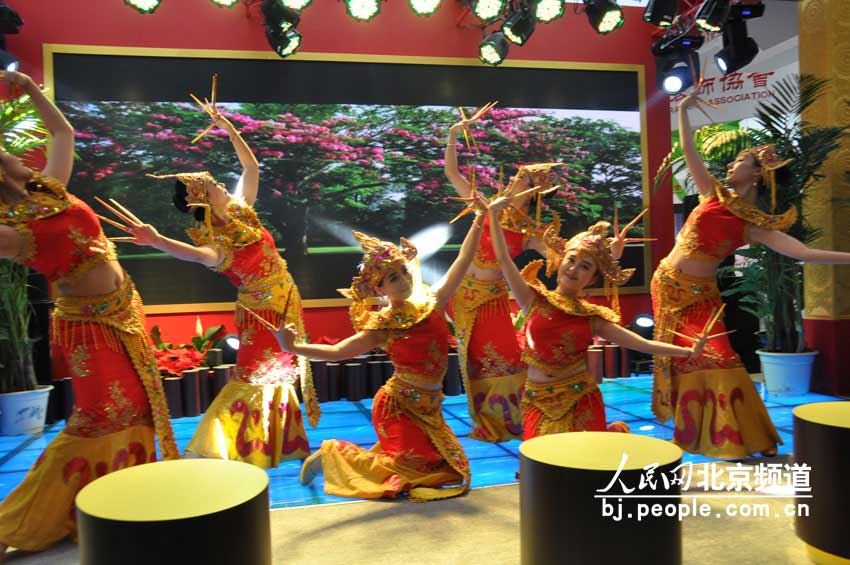 云南馆展台前的少数民族歌舞表演。 人民网 董纬摄