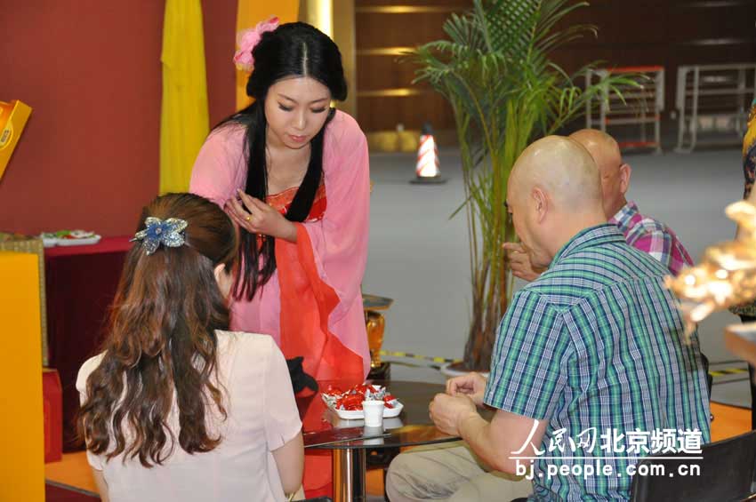 古装少女在为游客进行茶艺表演。 人民网 董纬摄