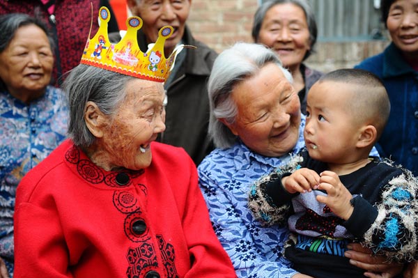 Wang Jingzhi laughs at her great-grandson Zhu Rongkang at her 113th birthday party in Yanggu county, Liaocheng city, East China's Shandong province, May 27, 2013. [Photo by Zhang Zhenxiang/Asianewsphoto] 