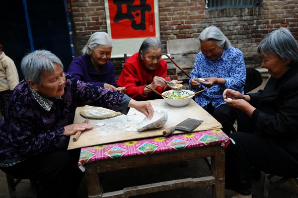 Wang Jingzhi makes dumplings with her four daughters in preparation of her 113th birthday celebration in Yangu county, Liaocheng city, East China's Shandong province, May 27, 2013. [Photo by Zhang Zhenxiang/Asianewsphoto]