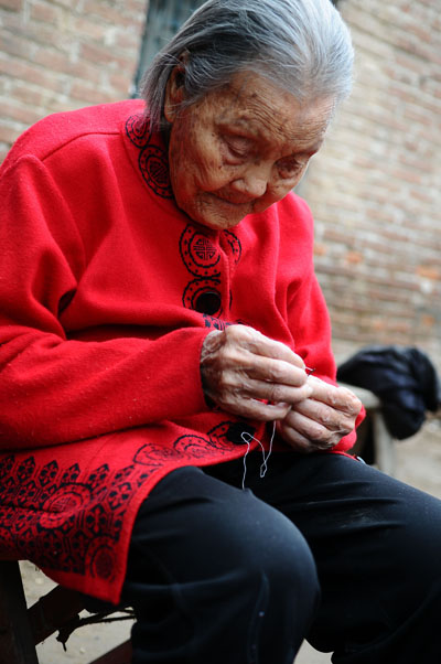 Wang Jingzhi can still thread a needle at 113 in Yanggu city, Liaocheng county, East China's Shandong province, May 27, 2013. [Photo by Zhang Zhenxiang/Asianewsphoto] 