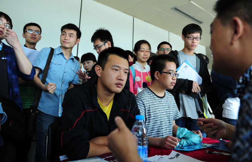 Students attend a job fair held in Xi’an, Shaanxi Province, on May 29, 2013. China will see a record-high 6.99 million people graduate from college this year, up 2.8 percent year on year, according to official figures. 