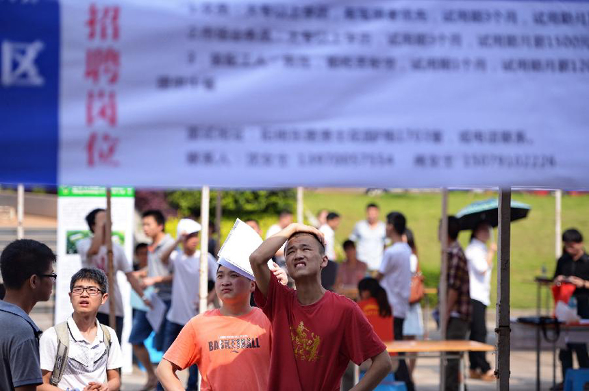 College students look at information at a job fair in the Nanchang University in Nanchang, capital of east China&apos;s Jiangxi Province, May 23, 2013. Dozens of enterprises attended the job fair, providing nearly 18,000 job vacancies.