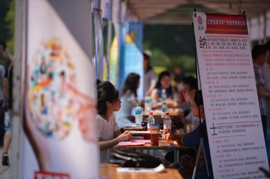Applicants talk with employers at a job fair in the Nanchang University in Nanchang, capital of east China&apos;s Jiangxi Province, May 23, 2013. Dozens of enterprises attended the job fair, providing nearly 18,000 job vacancies. 