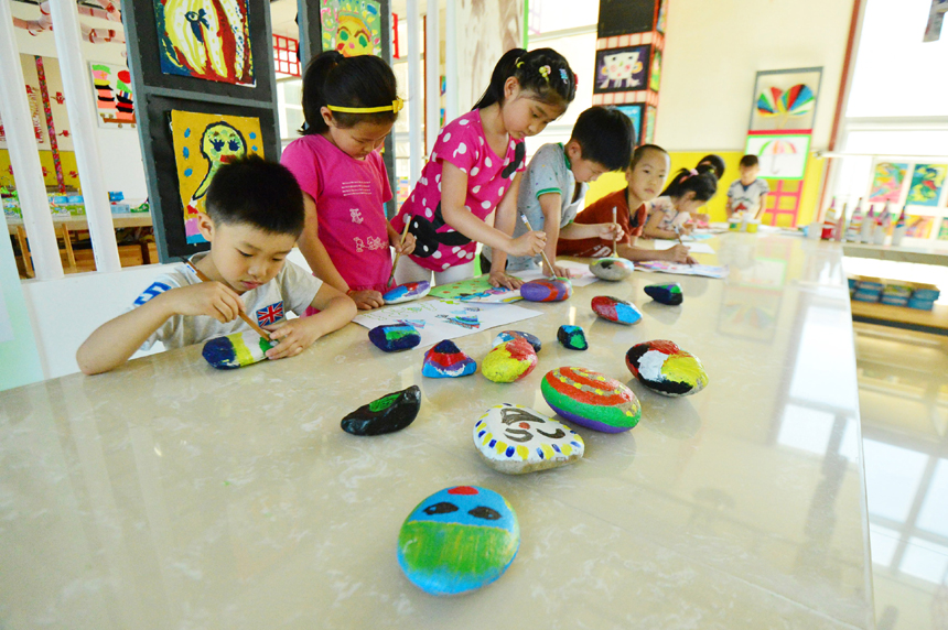 Children draw pictures on stones in a kindergarten of Miyun County in suburb Beijing on May 29. Various kinds of activities are held nationwide to celebrate the International Children’s Day which falls on June 1. 