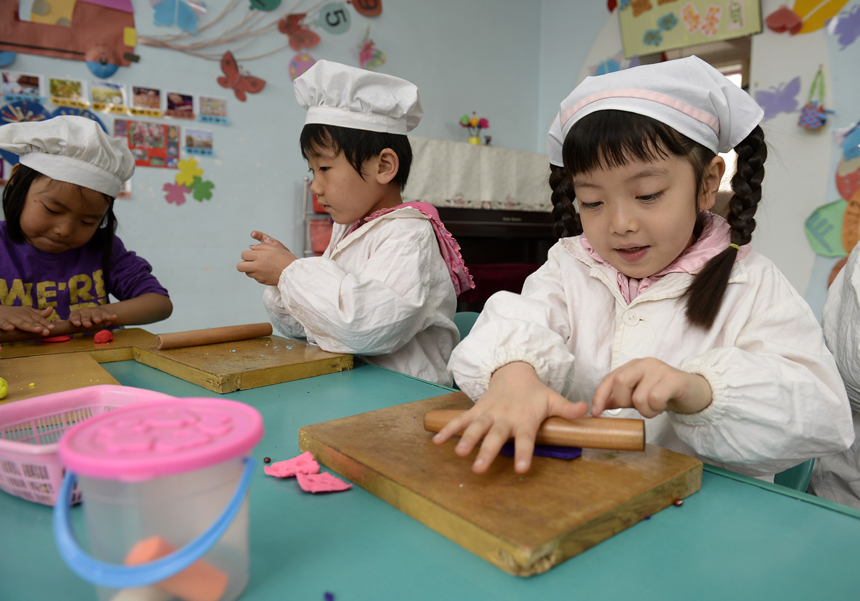 Children play a game of “cooking” in a kindergarten in Yinchuan, Ningxia Hui Autonomous Region, on May 30. Various kinds of activities are held nationwide to celebrate the International Children’s Day which falls on June 1. 