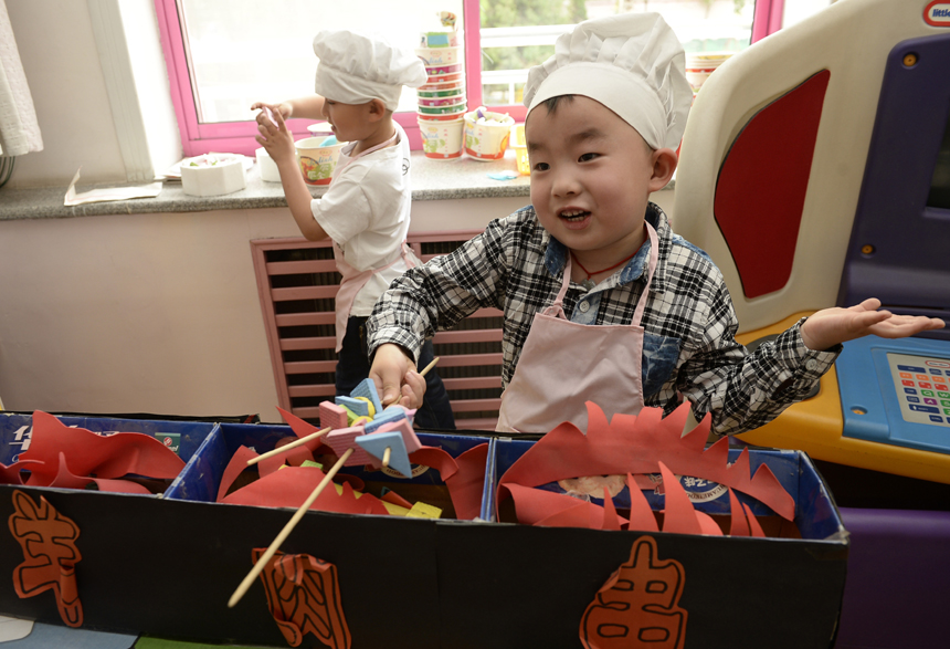 Children play a game of “cooking” in a kindergarten in Yinchuan, Ningxia Hui Autonomous Region, on May 30. Various kinds of activities are held nationwide to celebrate the International Children’s Day which falls on June 1. 