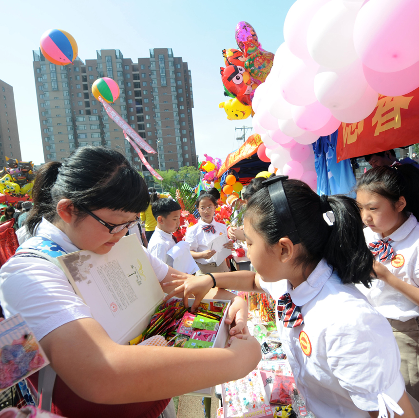 Students exchange gifts in a primary school in Shenyang, Liaoning Province, on May 31. Various kinds of activities are held nationwide to celebrate the International Children’s Day which falls on June 1. 