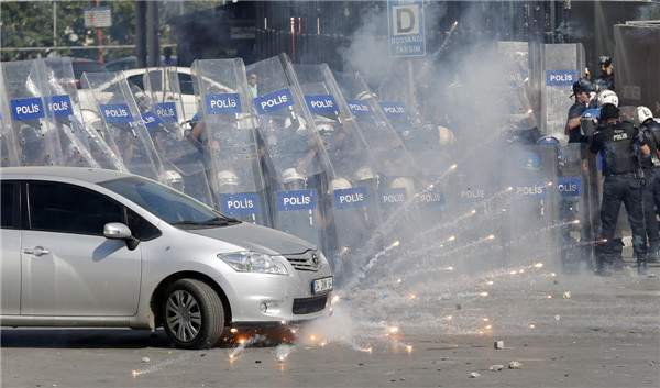 Riot police behind shields fire tear gas as they clash with anti-government protesters at Taksim square in central Istanbul June 1, 2013. [Photo/Agencies]